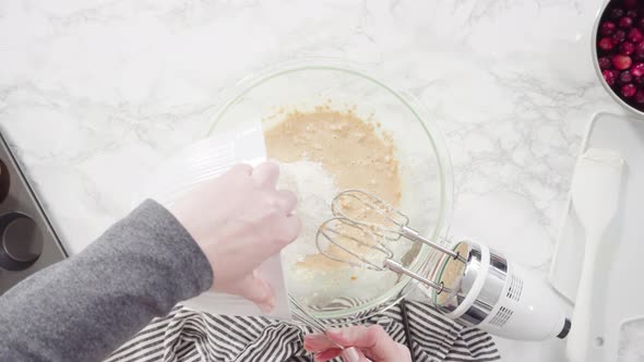 Flat lay. Step by step. Mixing ingredients in a mixing bowl to bake cranberry muffins.