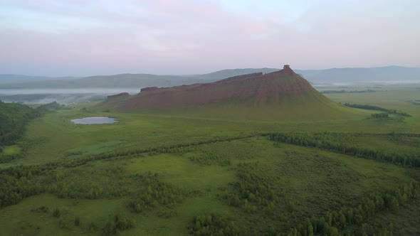 Flight to Red Mountain over Green Steppe