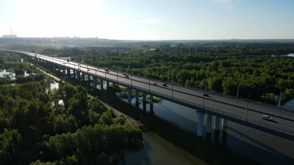 Road Bridge Over the Swamp in the Rays of the Back Sun