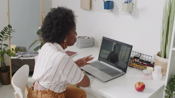 African American Woman Having Video Chat on Laptop from Home