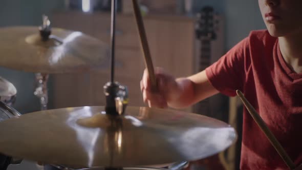 Teenager Learning to Play Drum Kit