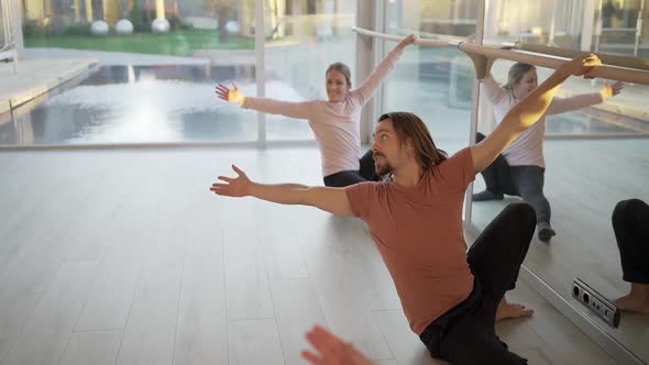 People doing yoga in Side Lunge pose near barre