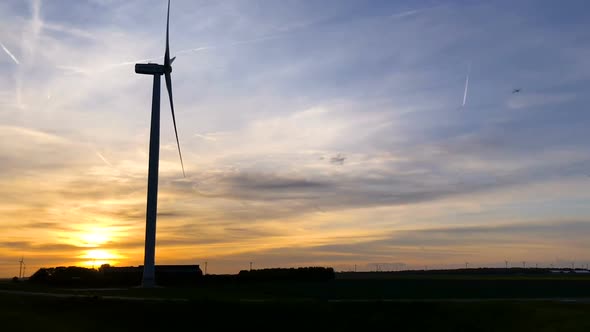 Rotating wind turbines at sunset