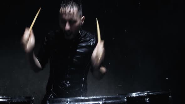 The Drummer on the Drum Wooden Sticks and Water Drops Flying in All Directions.