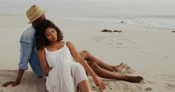 African American couple relaxing together on the beach 4k