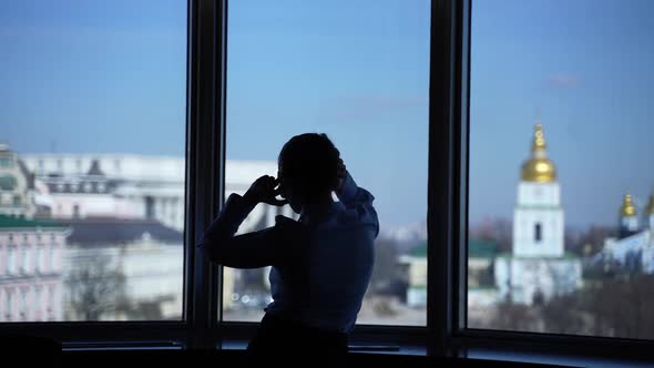 Silhouette of Female Dancing to Music Near Window