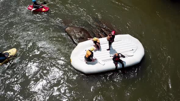 Close-up drone view of an upside down rafting boat and safety kayaks on the Nile River, Jinja, Ugand