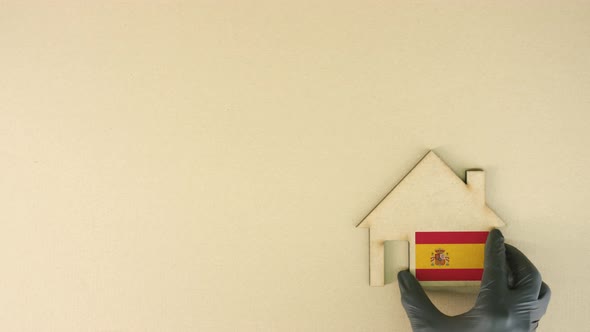 Placing Cardboard Home Icon with Printed Flag of Spain