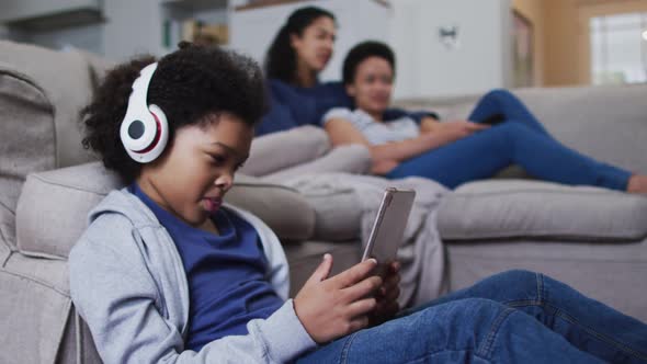 Mixed race girl using tablet wearing headphones