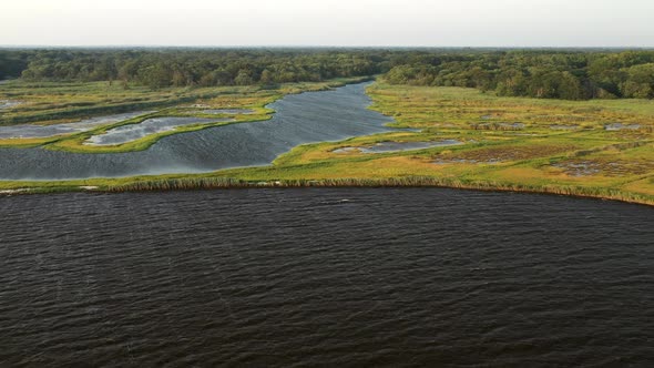 descending crane shot over the waters at East Islip Marina & Park focusing on the marsh area with a