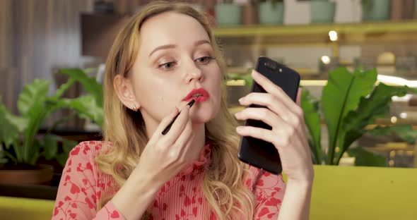 Attractive Young Girl Fixing Her Pink Lipstick, Applying Lip Makeup in Cafe