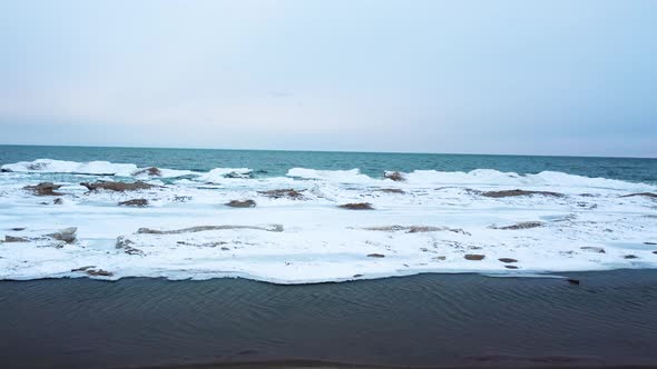 4K drone video flies from beach to icebergs.