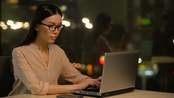 Attractive Asian Woman Typing on Laptop Sitting in Cafe With Wifi, Freelancer