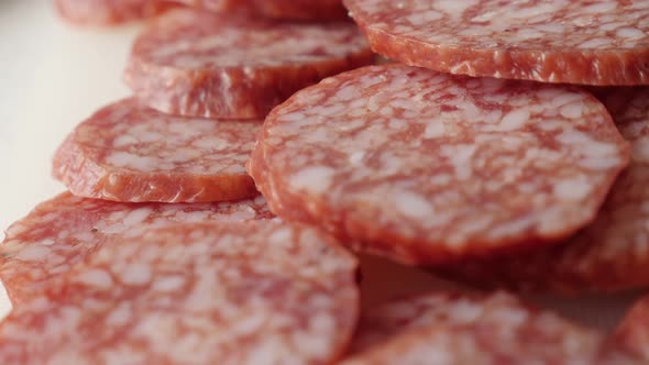 Tasty dry salami pieces on plate food background slow pan 4K 2160p 30fps UltraHD footage - Cured sau