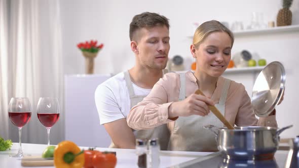 Happy Couple Cooking Together in Kitchen, Female Tasting Soup, Healthy Food