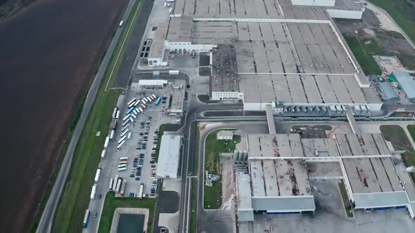 Huge industrial zone on field. Grey roofs of industrial plant among nature.