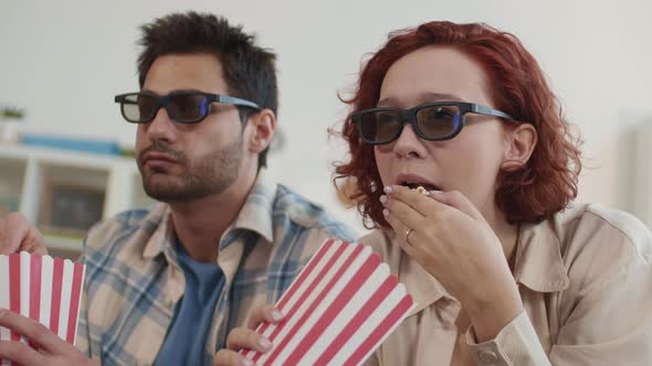 Couple in 3D-Glasses Eating Popcorn