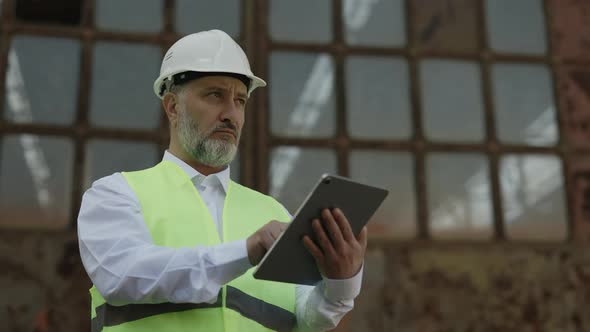 Inspector with Tablet Checking Construction Status Outdoor