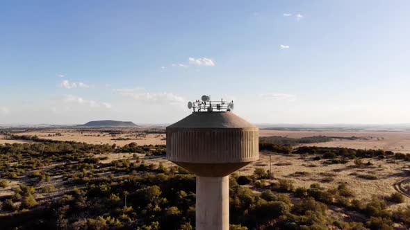 DRONE Drop Down Shot of a Broadcast Tower in a Rural Area on a Sunny Day