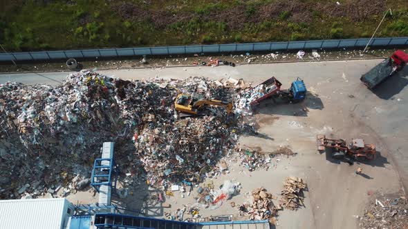 The excavator shovels up a bunch of garbage