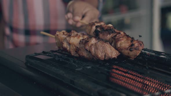 Chef Turns Meat Frying on Electric Barbecue in Street Cafe