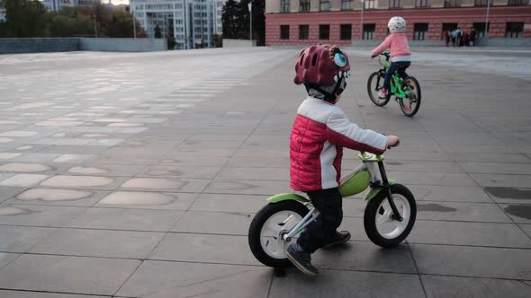 Little Smiling Happy Boy and Girl Are Riding Bicycles in a City Park, Close-up, Kharkov, Ukraine