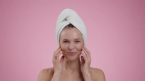 Happy Middle Aged Woman Making Skin Lifting Facial Massage After Shower Pink Studio Background Slow