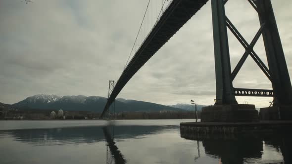 Wide shot Under Lions Gate suspension Bridge in Stanley Park, Vancouver, Cloudy, Slowmotion