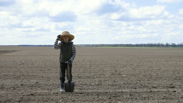 The Farmer Boy in the Field Holds a Hat