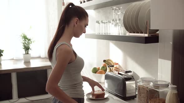 Woman Cooking Toasts On Breakfast At Modern Light Kitchen