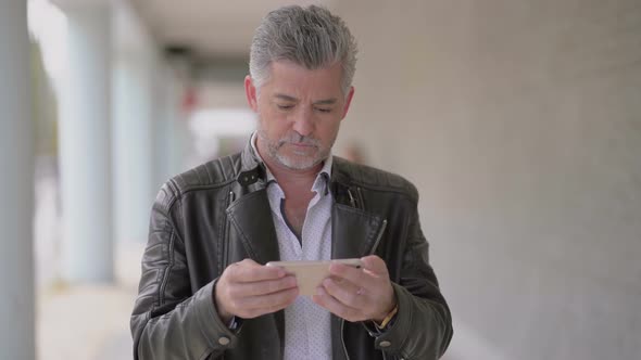 Focused Mature Man Using Mobile Phone