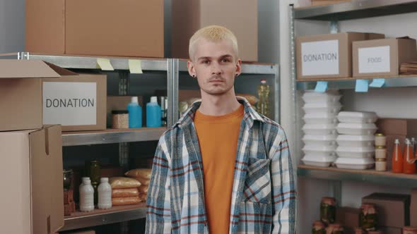 Man in Casual Wear and Earrings Posing at Food Bank Storage