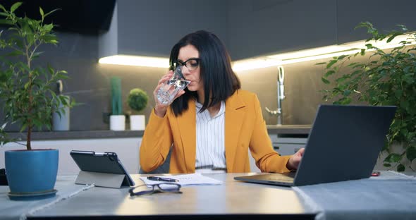 Woman in Glasses and Stylish Jacket Working with Documents and Laptop