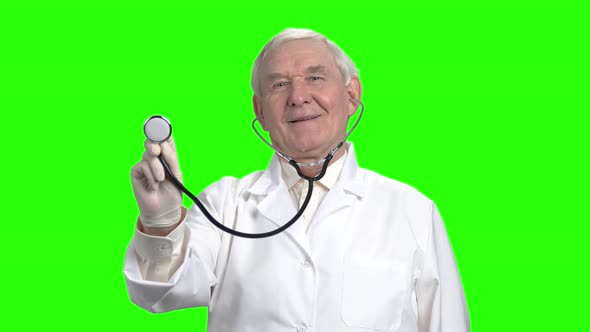 Old Doctor Using Stethoscope and Smiling.