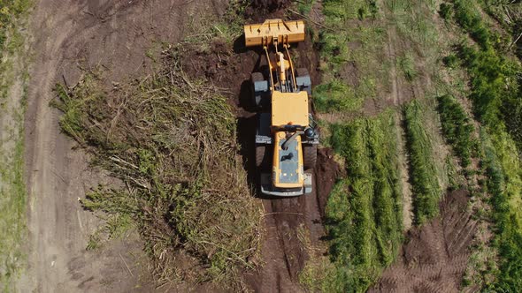 Bulldozer on countryside meadow. Top down view of bulldozer working on the field