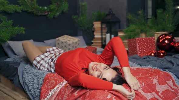 Very beautiful girl rolling in bed and posing to the camera. 