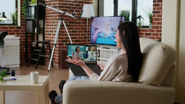 Young Adult Person with Portable Computer Doing Remote Work While Talking on Online Meeting