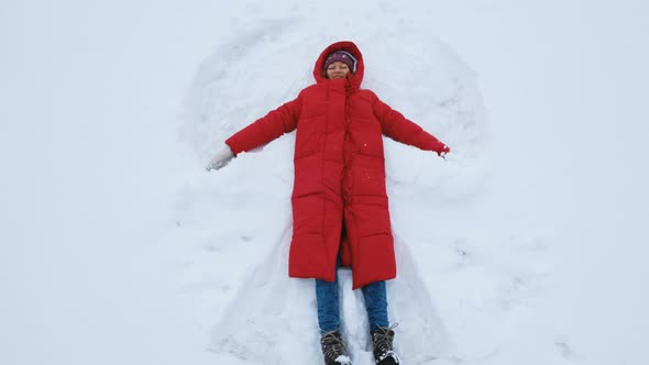Happy Woman Doing a Snow Angel, Top View