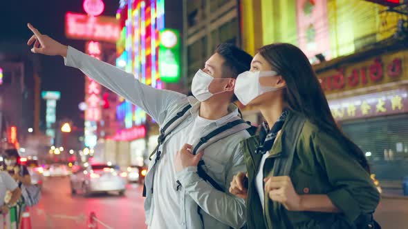 Asian attractive couple travel in the city for honeymoon trip at night.