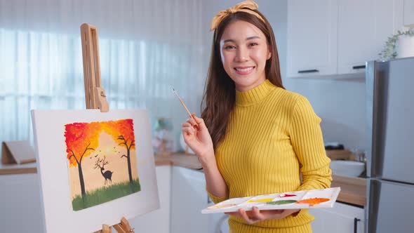 Portrait of Asian young artist girl coloring on painting board at home.