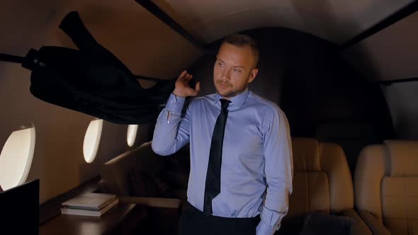 Portrait of Businessman Throwing a Jacket on His Shoulder in Private Jet.