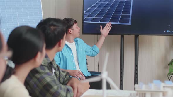 Asian Man Engineer In Wheelchair Presenting About The Work Of Solar Cell To His Colleagues