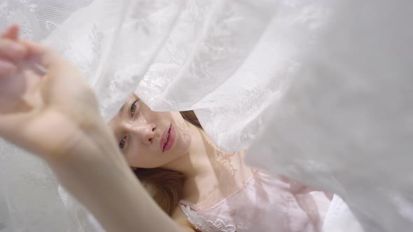 Sensual Woman Lying in Bed with Canopy