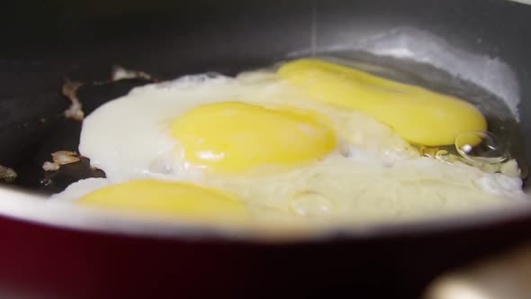 Cooking Fried Eggs in a Frying Pan for Breakfast