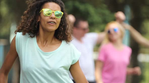 Biracial Female Artist Dancing, Singing in Front of Camera, Crowd at Background