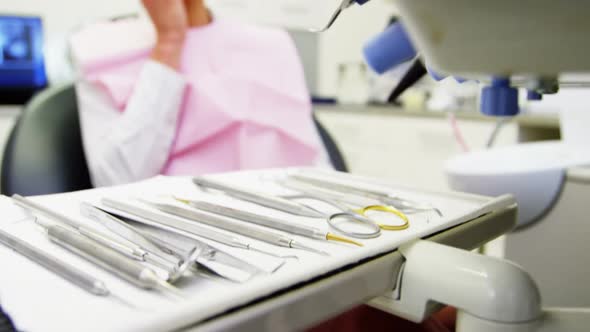 Scared female patient looking at dental tools