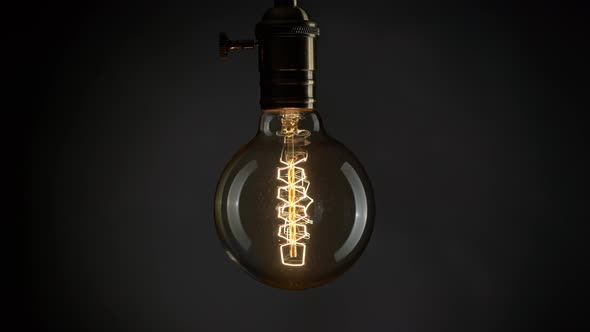 Edison Old Retro Light Bulb Lamp Shaking Over Black Background