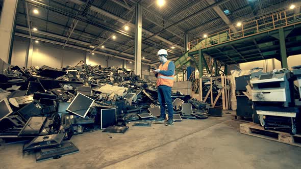 Broken Computers are Being Observed By a Male Junkyard Employee