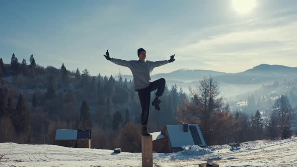Aerial View, Man Practicing Yoga on the Background of Winter Mountains.