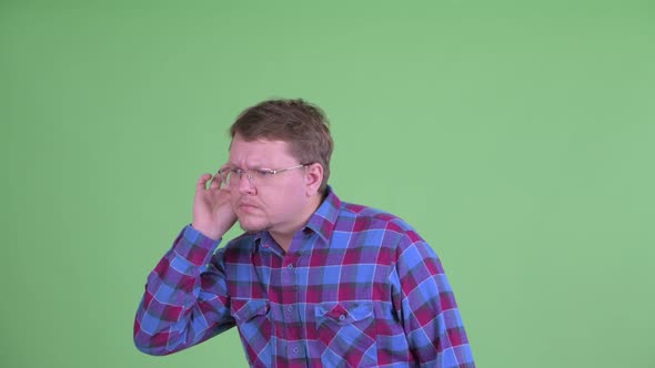 Stressed Overweight Bearded Hipster Man Listening and Getting Bad News